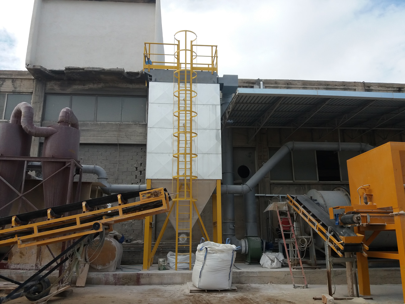 Dedusting filter with external insulation and heating elements for dedusting a raw material dryer